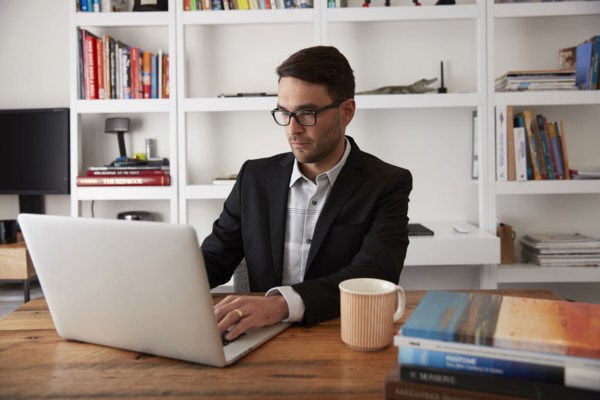 Caucasian businessman using laptop in home office