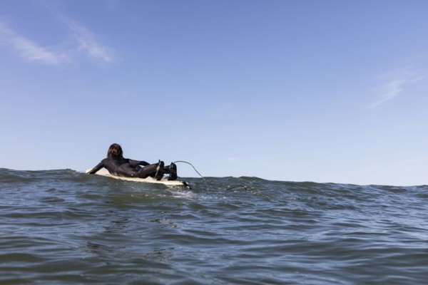 Caucasian man paddling on surfboard
