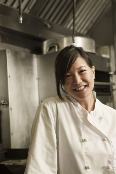 Smiling Chinese chef standing in commercial kitchen