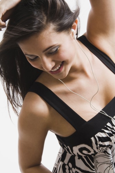 Mixed race woman listening to headphones and dancing