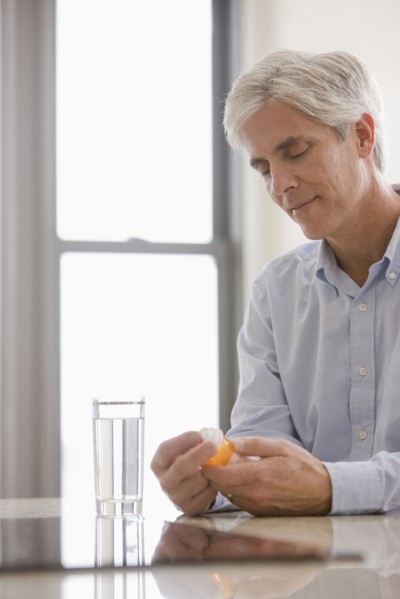 Caucasian man taking medicine