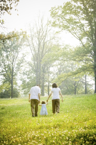 Parents walking with daughter in field