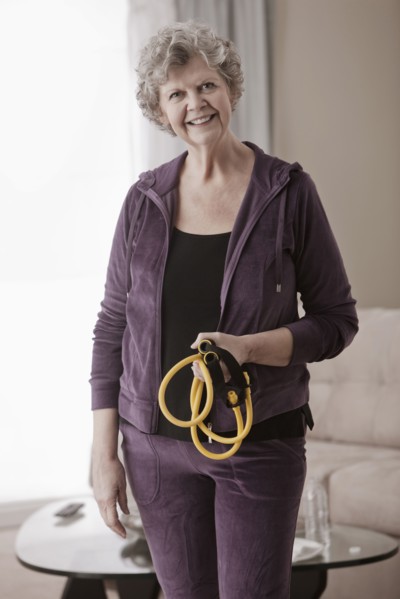 Caucasian woman holding exercise bands in living room