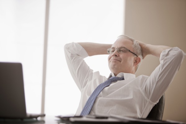Caucasian businessman sitting at desk with hands on head