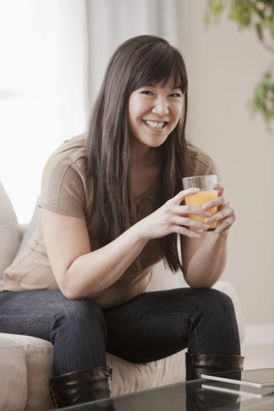 Asian woman drinking orange juice