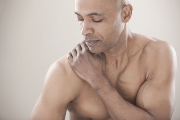 Black man rubbing his shoulders