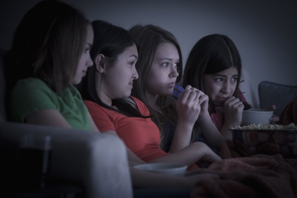 Friends eating popcorn and watching a movie
