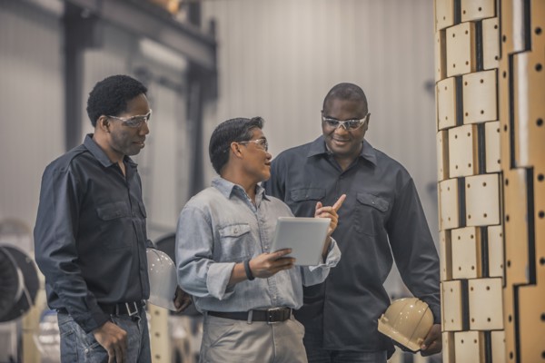 Workers looking at equipment in factory