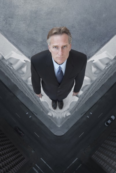 Caucasian businessman on skyscraper ledge
