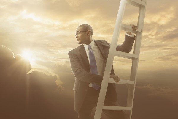 African American businessman climbing ladder
