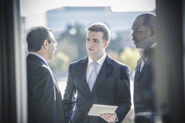 Businessmen using digital tablet outside office