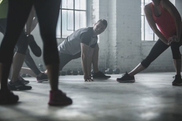 Athletes stretching legs in gym
