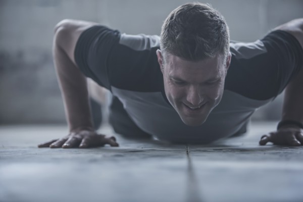 Caucasian athlete doing push-ups on floor