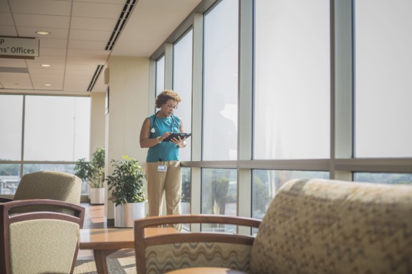 African American doctor using digital tablet at window