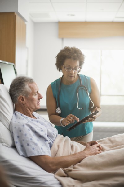 Doctor using digital tablet with patient