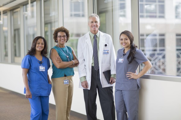 Doctor and nurses smiling in hospital hallway