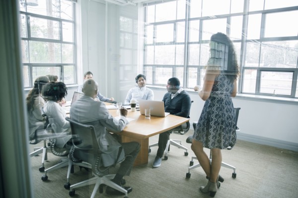 Businesswoman talking behind window in meeting