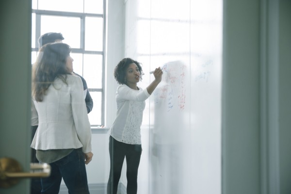Businesswoman writing on whiteboard in meeting