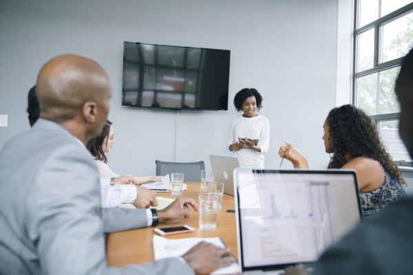 Businesswoman talking near visual screen in meeting