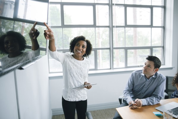 Businesswoman talking near visual screen in meeting