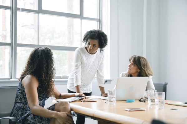 Businesswomen using laptop in meeting