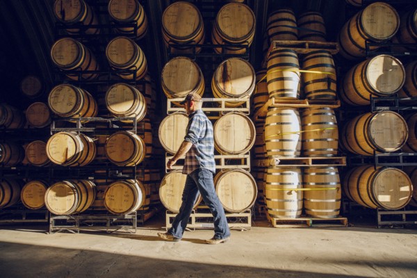 Caucasian man walking near barrels in distillery