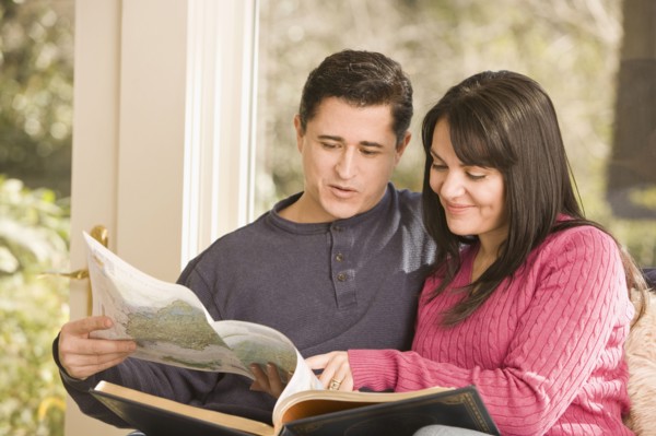 Hispanic couple looking at atlas