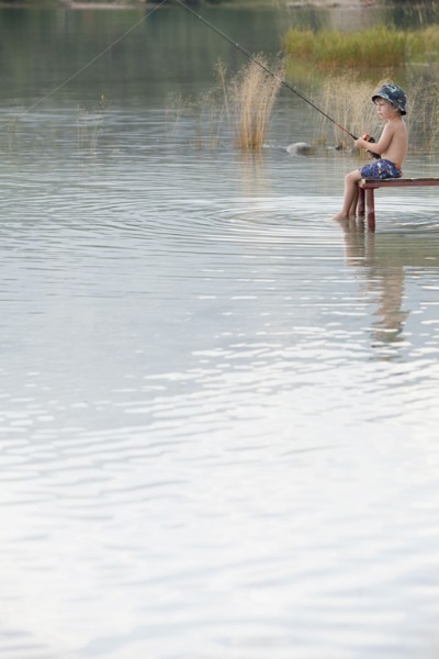 Caucasian boy fishing in lake