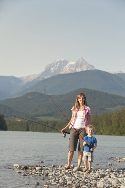 Caucasian mother and son fishing in remote lake