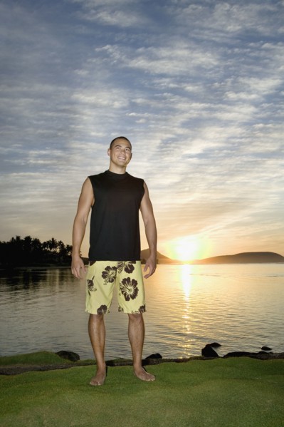 Asian man next to water at sunset
