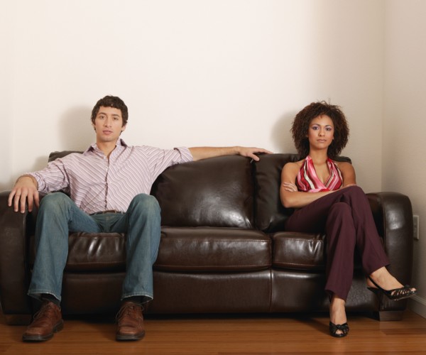 Multi-ethnic couple sitting on sofa