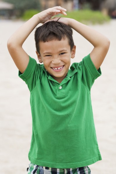 Mixed race boy smiling on beach