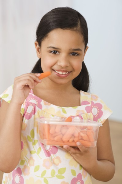 Hispanic girl eating carrots