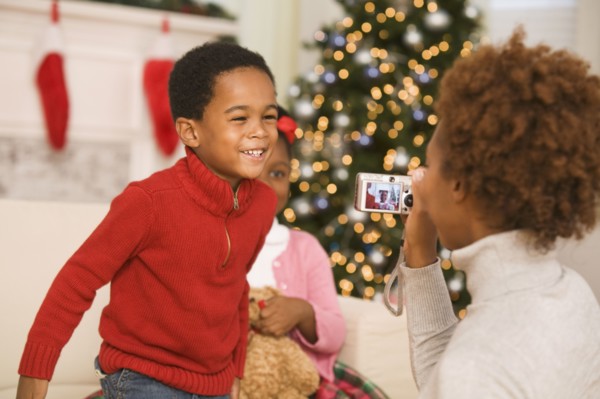 African mother taking picture of son at Christmas