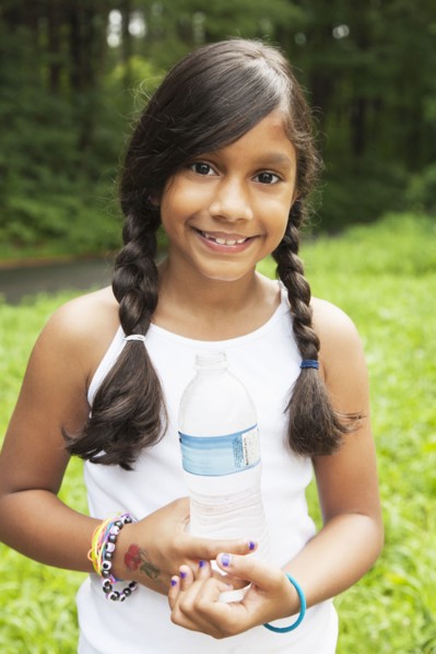 Smiling Hispanic girl holding bottled water