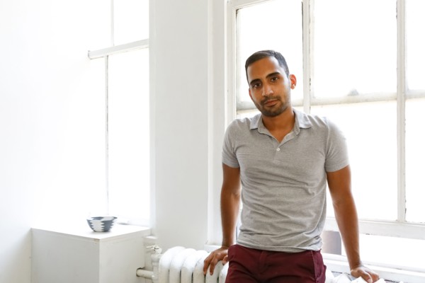 Mixed race man leaning on radiator