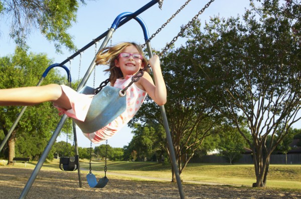 Hispanic playing on swings in park