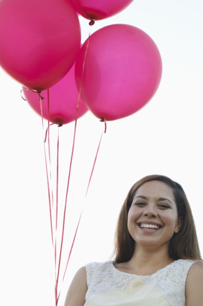 Mixed race woman with pink balloons