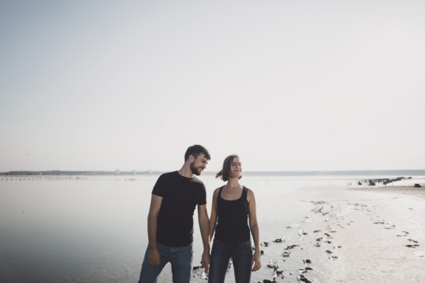 Caucasian couple holding hands on beach