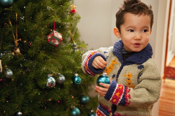 Mixed race boy decorating Christmas tree