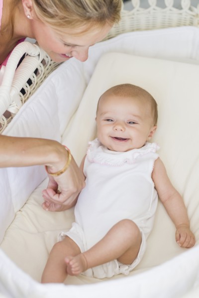 Caucasian mother looking at baby in bassinet