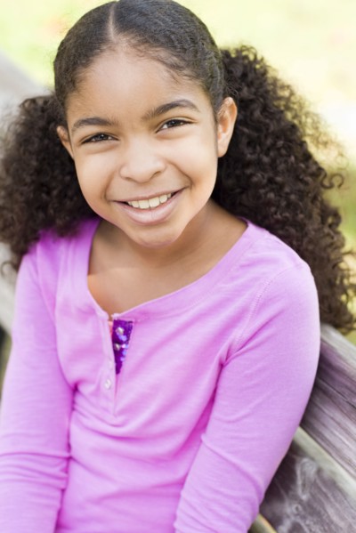 Cape Verdean girl smiling on park bench