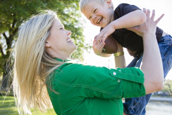 Caucasian woman playing with son