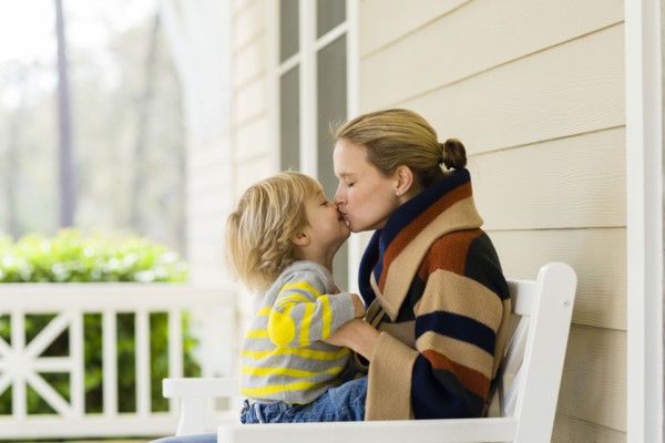 Caucasian mother and son kissing