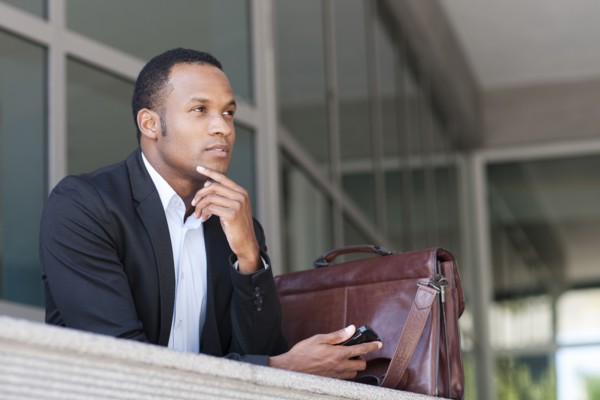 Black businessman thinking outside building