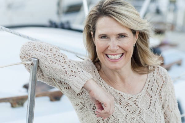 Caucasian woman leaning on boat in harbor