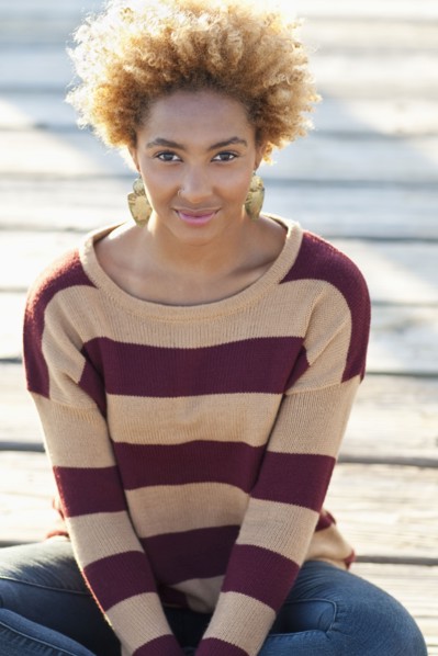 Black woman sitting on wooden boardwalk