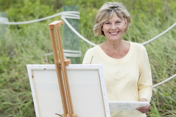 Older Caucasian woman painting outdoors