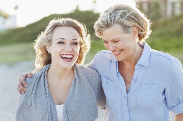 Caucasian mother and daughter hugging on beach