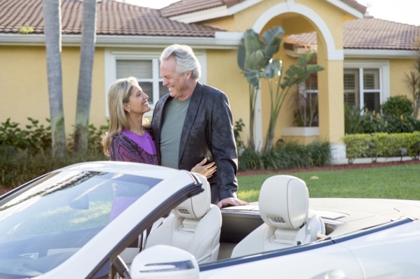 Caucasian couple smiling near convertible